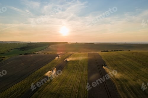 Preview: Aerial view of combine harvesters working during harvesting season on large ripe wheat field