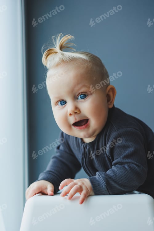 Preview: Cute little boy in a bodysuit with a smile on his face. The child looks at the camera, smiles.