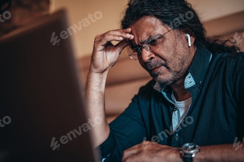 Preview: Senior hispanic cuban men using a laptop while having a headache from work stress
