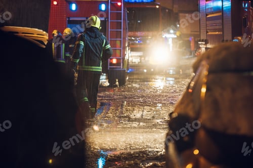 Preview: Firemen at work near their truck on the street.