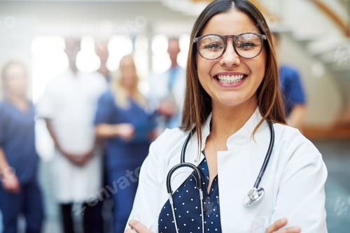 Preview: Smiling young doctor wearing glasses in clinic