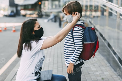 Preview: Mother adjusts her son's mask.