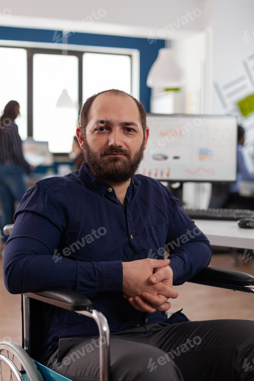 Preview: Portrait of smiling disabled businessman working at marketing strategy