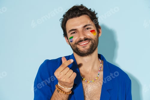 Preview: Shirtless man with rainbow flag rubbing his fingers and smiling