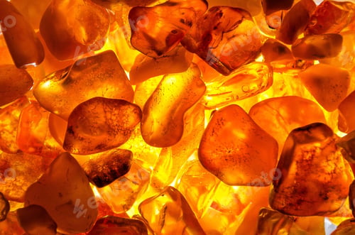 Preview: Closeup shot of a heap of amber stones with backlight background