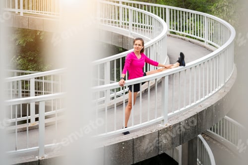 Preview: Young woman stretching outdoors on urban footbridge in pink sportswear