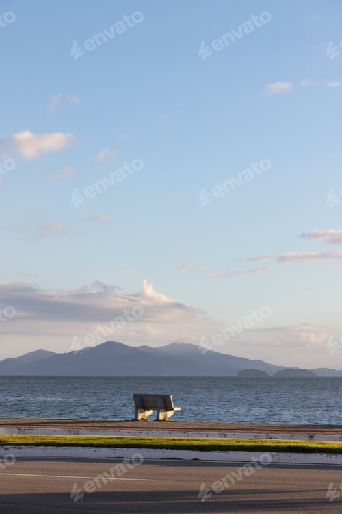 Preview: the bench is facing a body of water and mountains in the distance