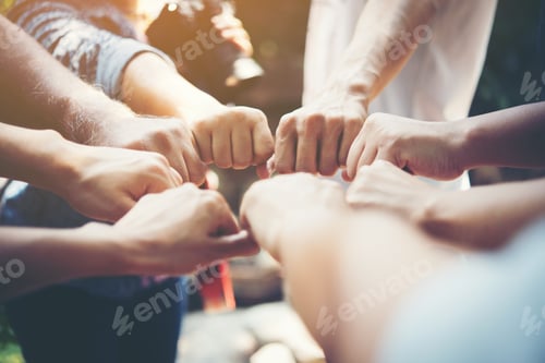 Preview: Close up of young people putting their hands together. Team with stack of hands showing unity.