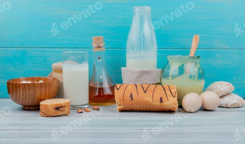 Preview: side view of milk products as cottage cheese, milk, condensed milk, cream with roll, almonds, butter
