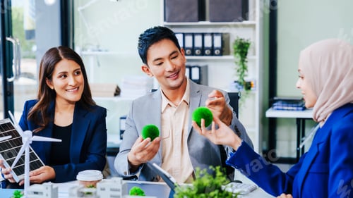 Preview: Trio of businesspeople, including a middle-aged Asian man and woman, strategize at their desk