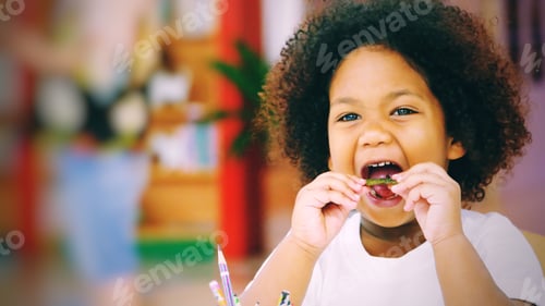 Preview: Child with Curly Hair Eating Green Vegetable