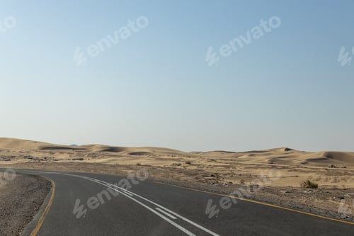 Preview: Isolated road winds through a vast desert landscape