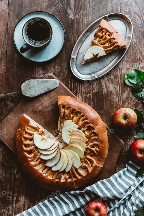 Preview: flat lay with piece of homemade apple pie, cake server, cup of coffee and fresh apples on wooden