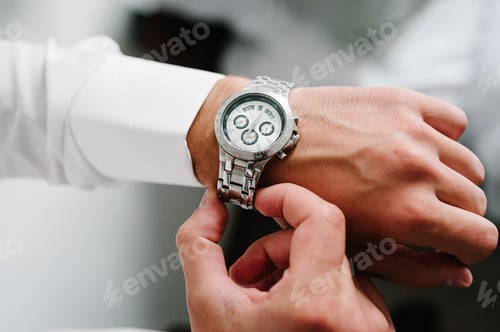 Preview: A man in a shirt adjusts the watch on his arm. Close up of businessman using watch.
