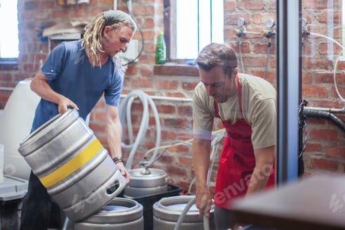 Preview: Colleagues in microbrewery cleaning beer kegs