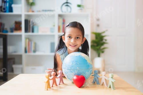 Preview: Asian little girl smiling behind the people, heart, globe model play toys.