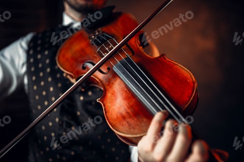 Male violinist playing classical music on violin