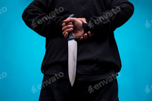Preview: Portrait Of Knife Held By Killer Man On Blue Studio Wall