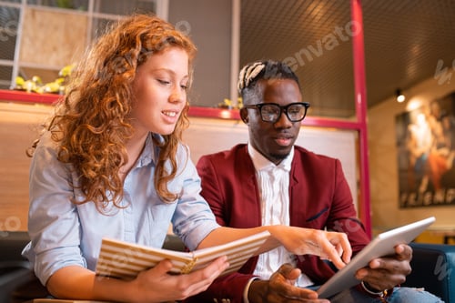 Preview: Young successful multicultural students or employees looking at touchpad display