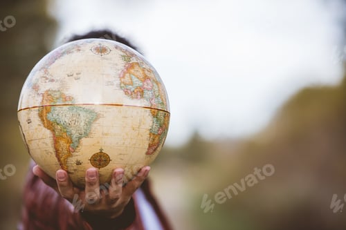 Preview: Closeup shot of a person holding a globe with a blurred background