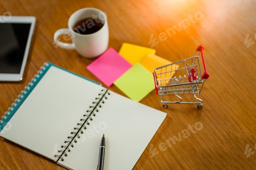 Preview: Laptop,note book,Note and small shopping cart on table. Internet shopping concept