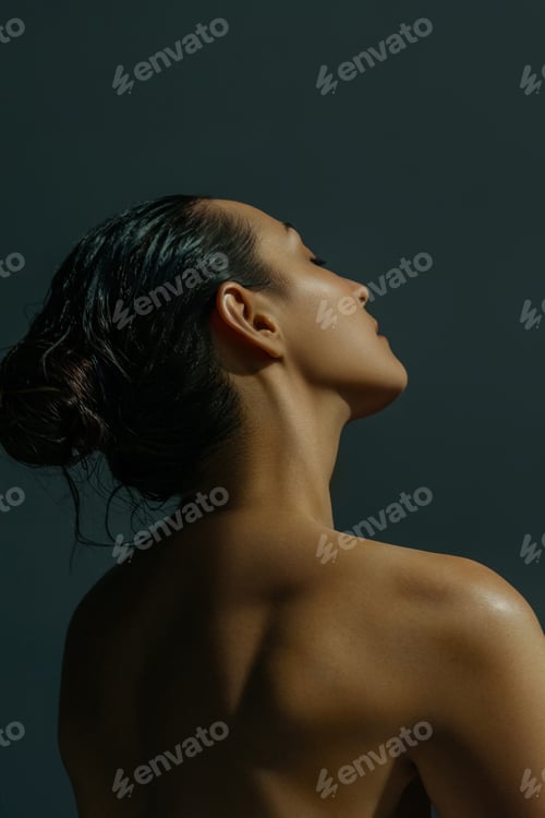 Preview: Elegant young woman with wet hair in sunlight from back