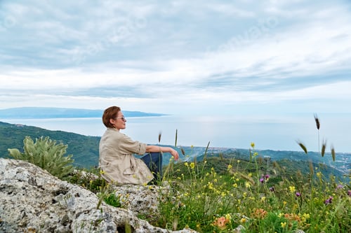 Preview: Female traveler enjoying freedom on the pick of mountain with serene fall nature.