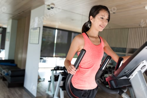 Preview: Sport Woman training on Elliptical machine at gym
