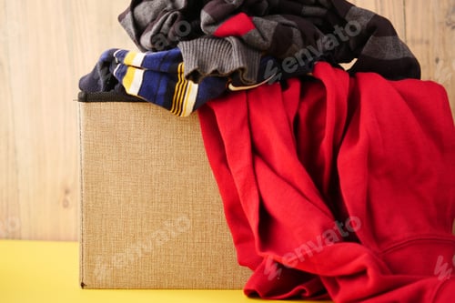 Preview: Donation box with donation clothes on a wooden table .