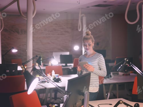 Preview: woman working on digital tablet in night office