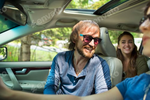 Preview: A group of people inside a car, on a road trip. A driver and two passengers.
