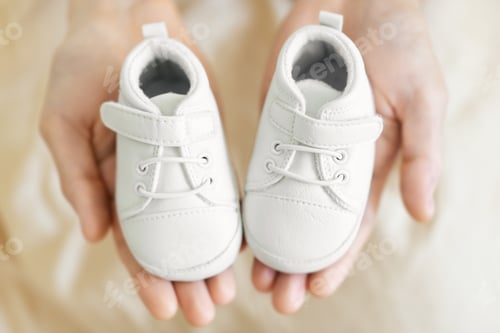Preview: Small cute baby shoes in fathers hands