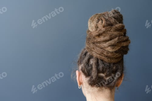 Preview: Back View of Unrecognizable Woman with Dreadlocks in Bun Hairstyle