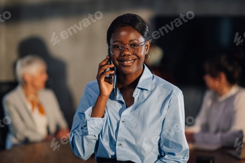 Preview: Smiling multiracial businesswoman having phone call at boardroom.