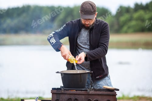 Preview: Man Adding Oil to Pot Outdoors