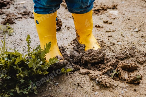 Preview: 🌟Nominated 🌟Child legs in yellow muddy rubber boots on wet mud