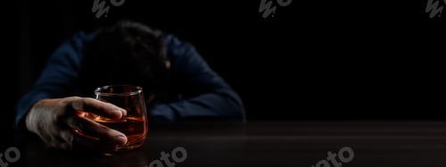 Preview: A man drinks whiskey, a businessman relieves stress from work sitting and drinking whiskey in the of