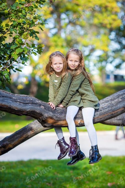 Preview: Little adorable girls outdoors at warm sunny autumn day