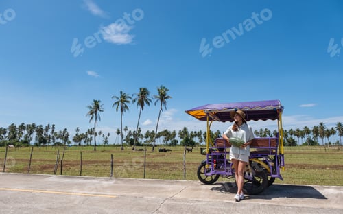 Preview: asian woman holding watermelon next to the sidecar while traveling in countryside