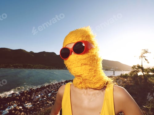 Preview: Beach, sunglasses, yellow hat a woman wearing sunglasses and a yellow hat stands on a sunny beach