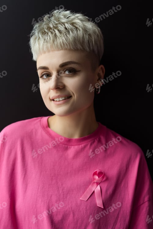 Preview: Young woman wearing pink ribbon supporting breast cancer awareness