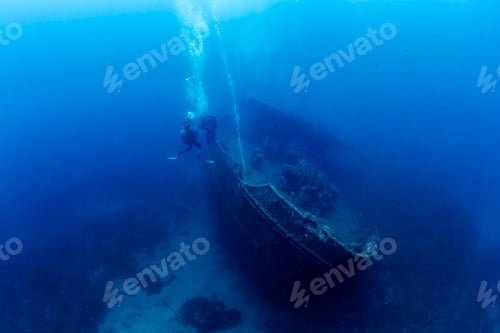 Preview: two divers diving near of the wreck of old ship