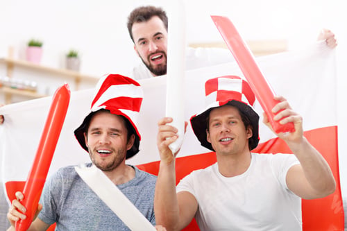 Preview: Happy male friends cheering and watching sports on tv