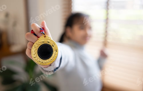 Preview: A happy Asian girl fencer bit a gold medal