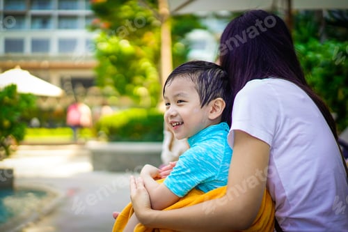 Preview: A boy with smiling face sit with mother at the park.