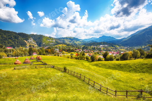 Preview: Stunning alpine landscape with green fields and Piatra Craiului mountains in Dambovicioara Commune