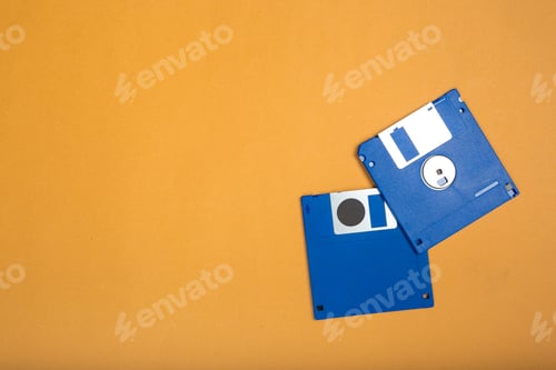Preview: Old floppy disks on an orange background showing retro technology and storage media types