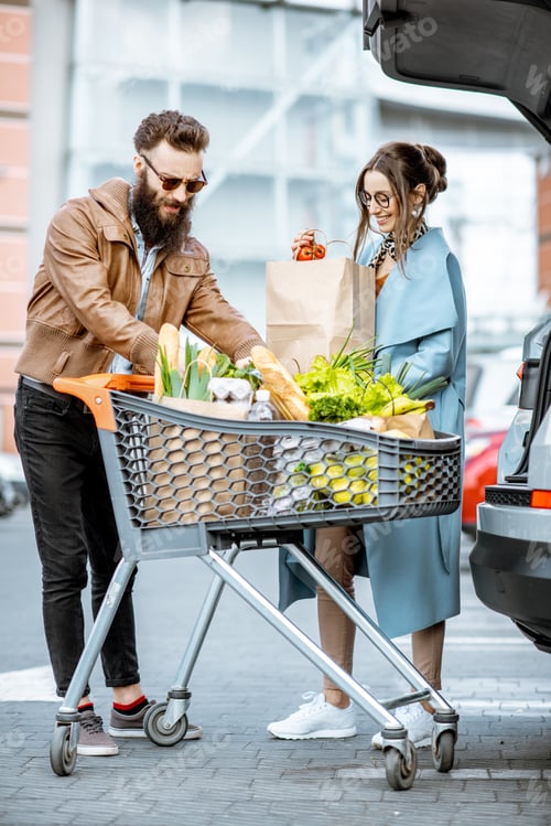 Preview: Man and woman with fresh food on the supermarket parking
