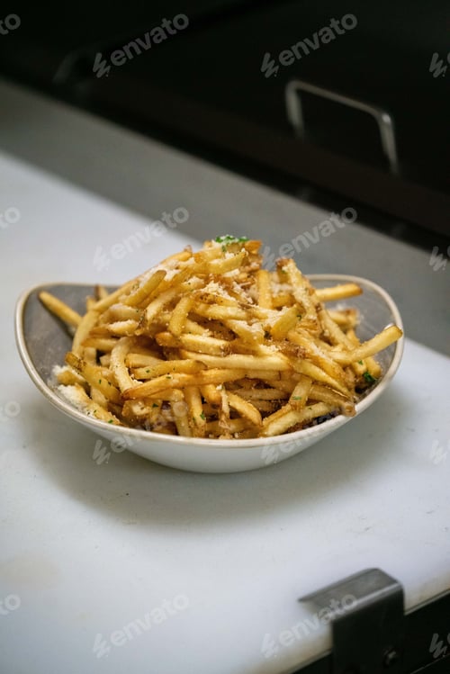 Preview: french fries are piled up in a bowl on a counter