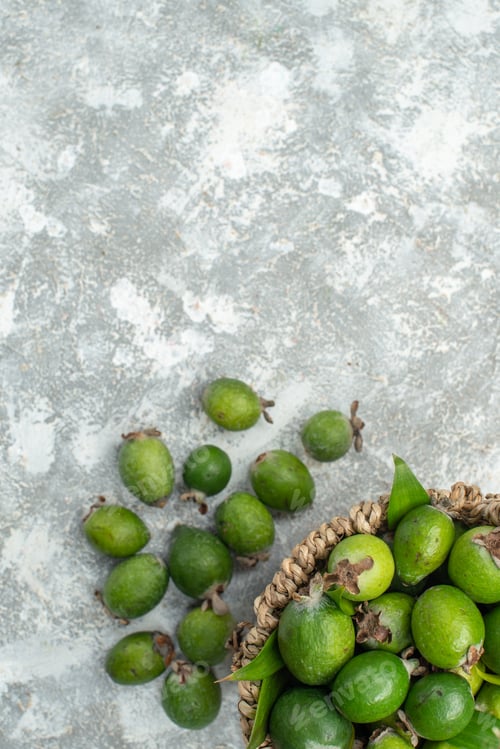 Preview: top view fresh feijoas in wicker basket on grey isolated background free place
